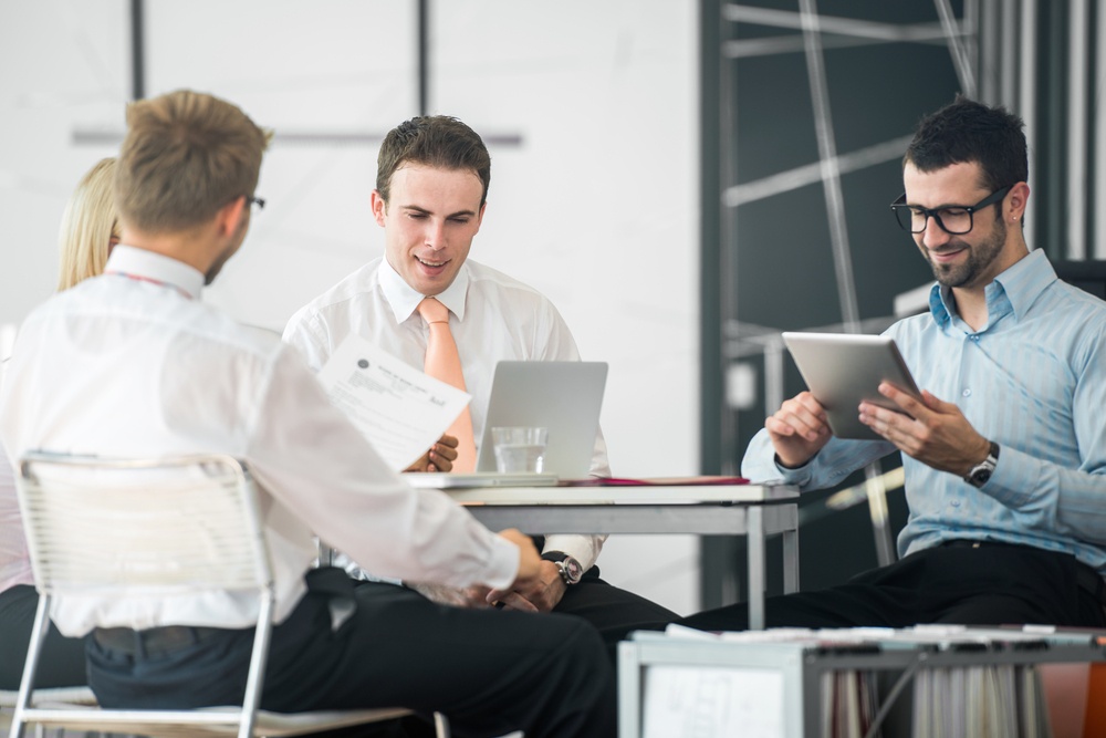 A group of corporate people working by the office table