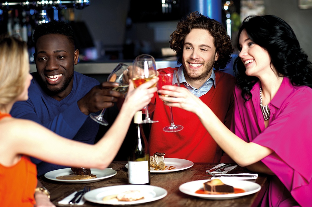 WEB - Group Sitting Round Wooden Table With Drinks, Celebrating, Cheers.jpeg